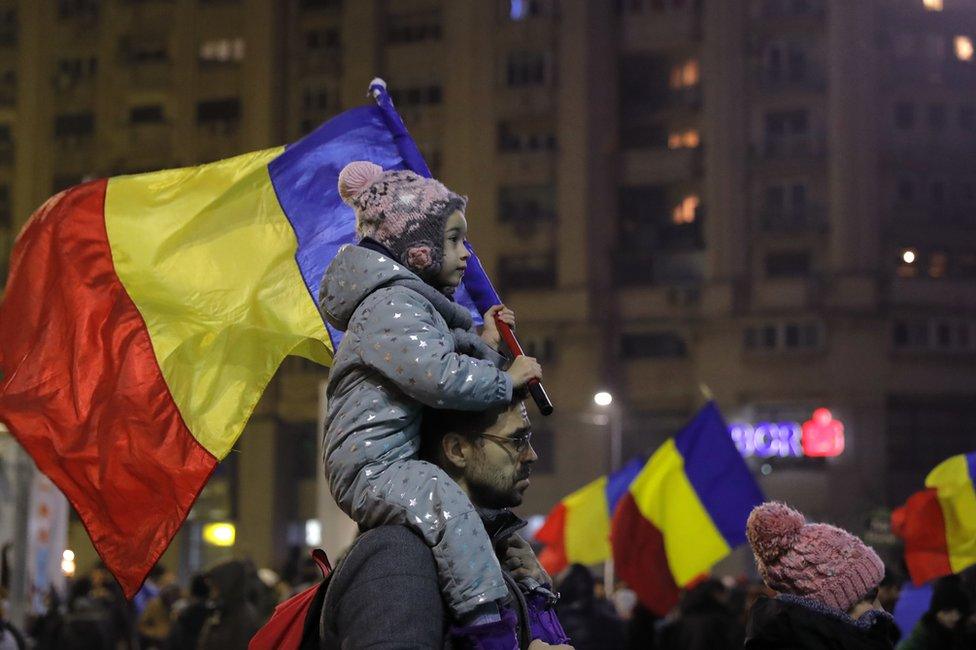 A child carries a Romanian national flag during a demonstration in Bucharest, Romania, 5 February