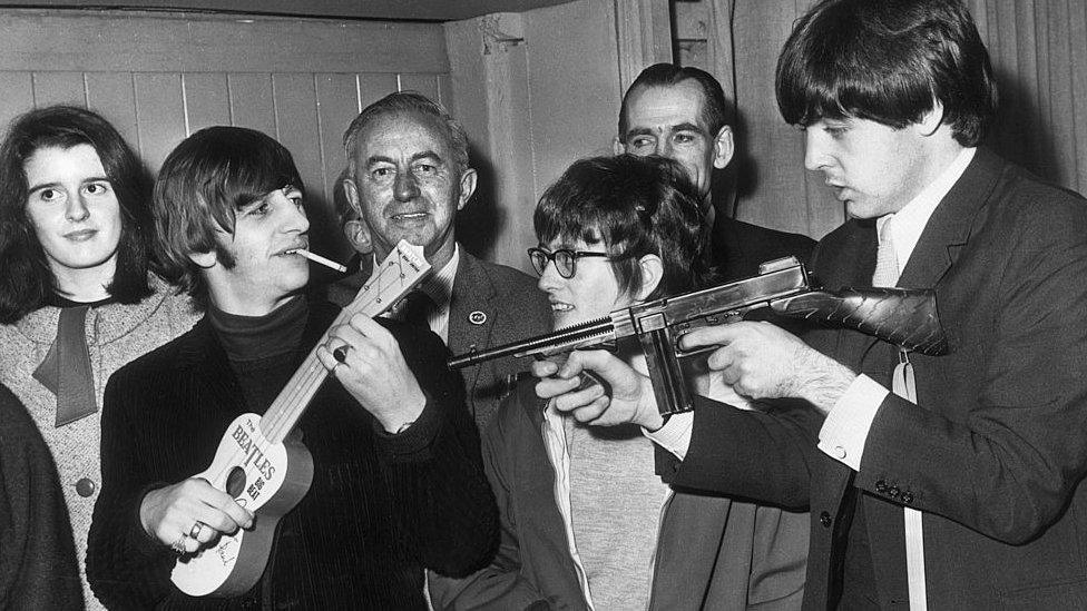 Ringo and Paul play with children's Christmas presents backstage at the King's Hall in 1964