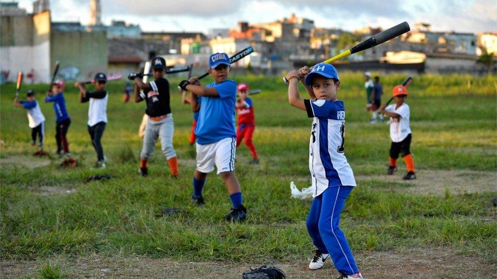 Cuban children practice baseball in a field of Havana