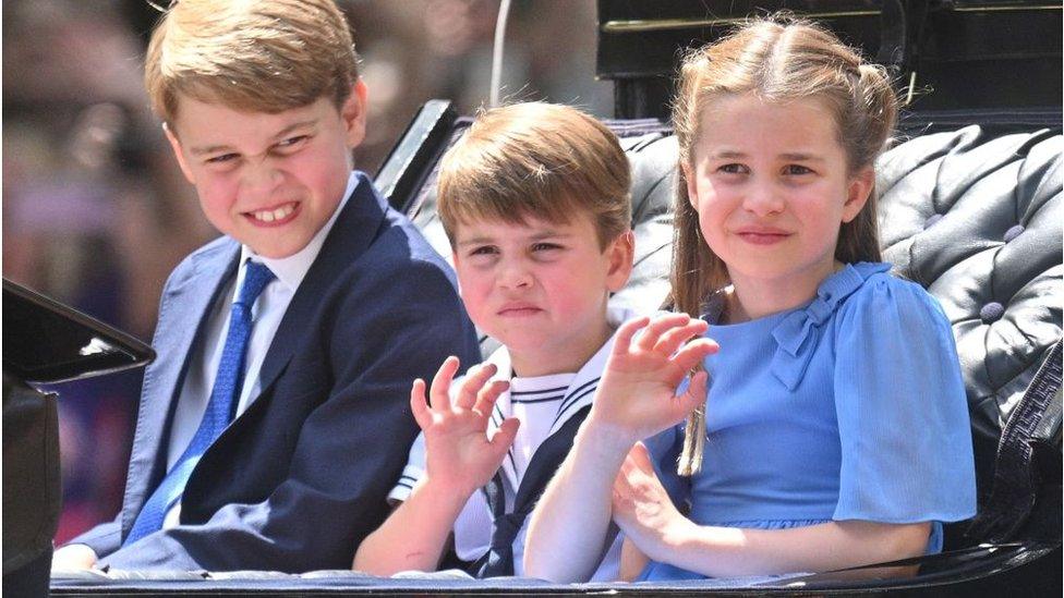 Prince George, Prince Louis, and Princess Charlotte ride in a carriage as the Royal Procession travels down The Mall to the Trooping the Colour ceremony