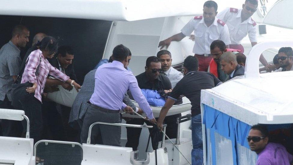 Officials carry an injured woman off the speed boat of Maldives President Abdullah Yameen (not pictured) after an explosion onboard in Male, Maldives (28 September 2015)