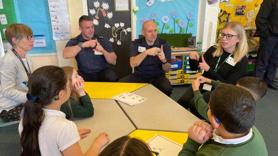 TWFRS firefighters being shown how to sign by pupils at Broadwood Primary school