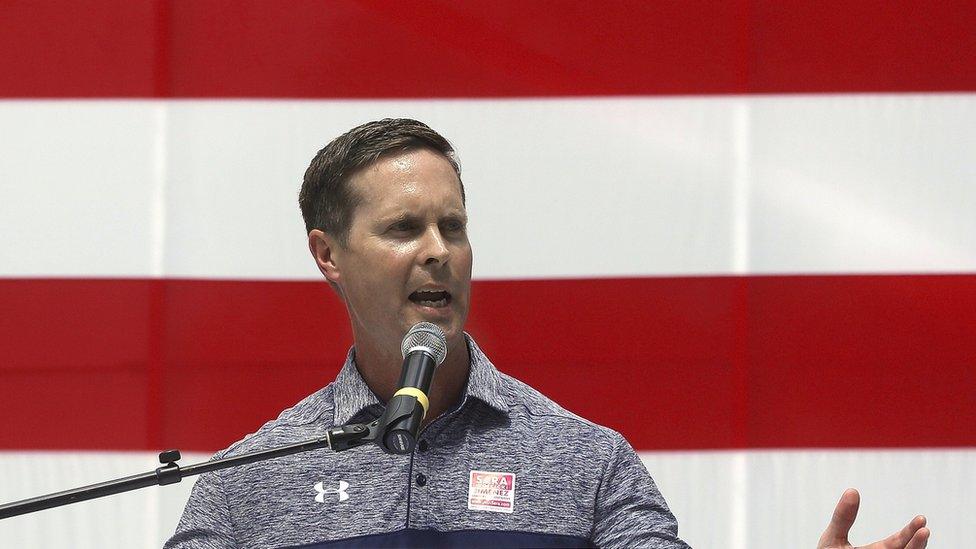 Rodney Davis in front of the stripes of a huge US flag, August 2016