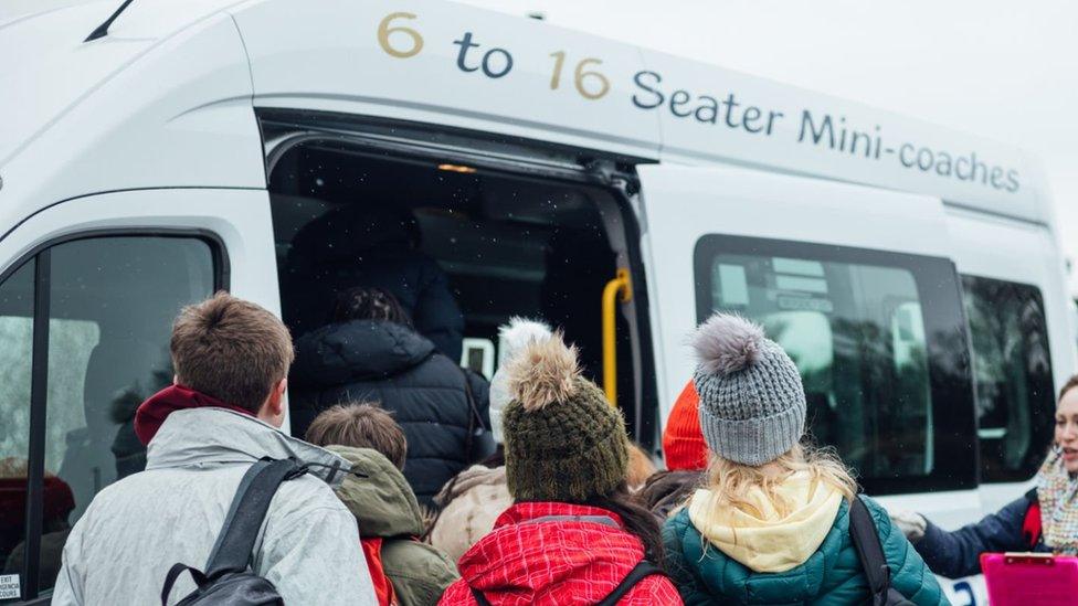 Stock photo of children boarding a mini-bus