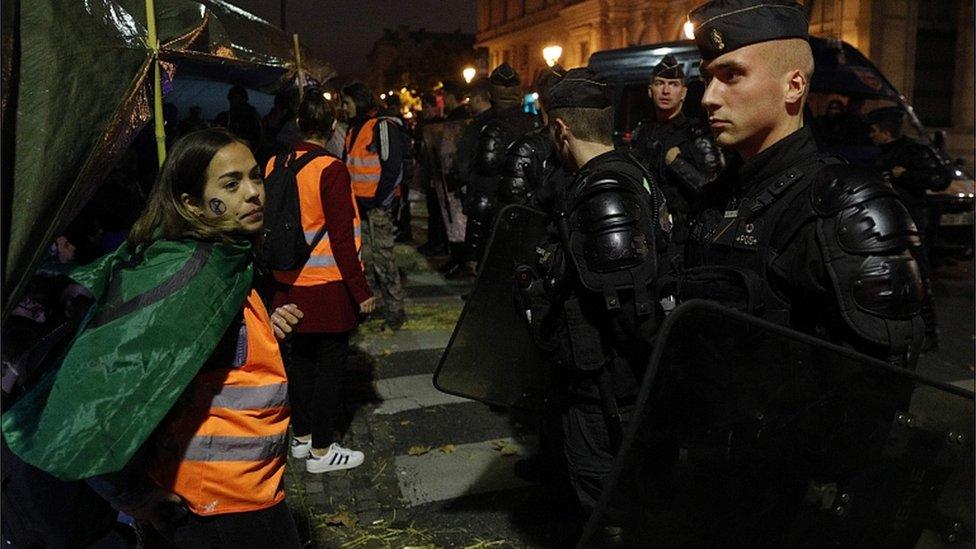 Extinction Rebellion "Guardian Angels" stand in front of French Gendarmes on October 7, 2019 in Paris