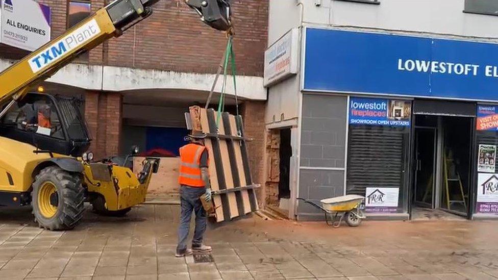 Banksy being removed from the side of an empty shop in Lowestoft