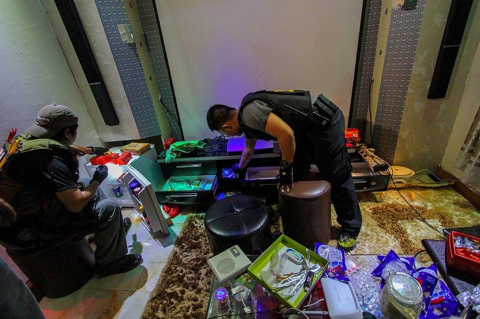 National Bureau of Investigation (NBI) operatives inspect the confiscated materials prohibited inside the New Bilibid Prison in Muntinlupa, south of Manila on 16 December 2014.