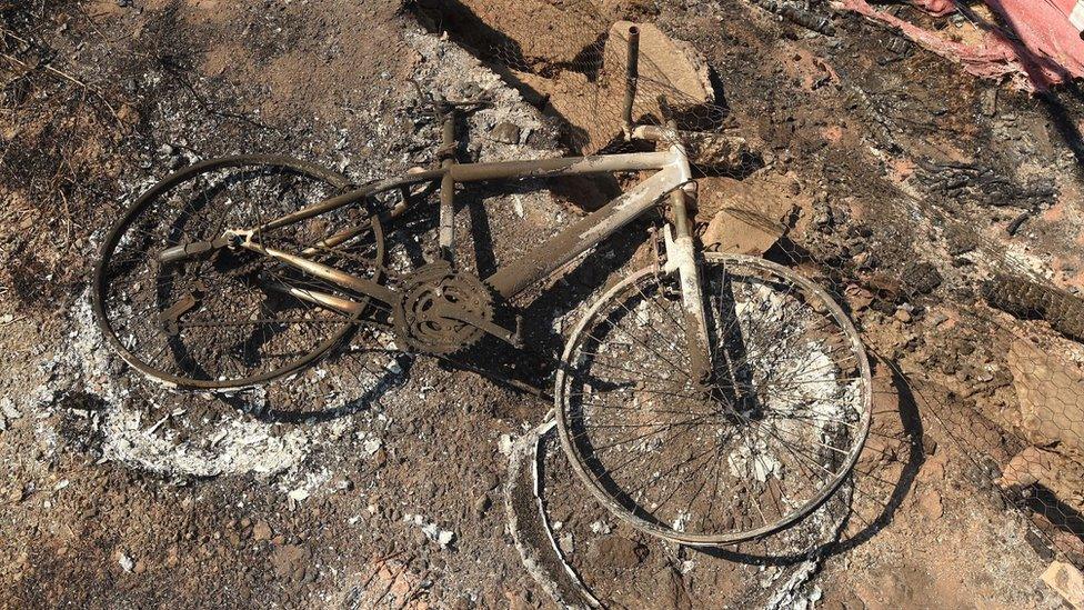 A destroyed bicycle amid the rubble of a burned property in Lower Lake, California, Monday, 15 August 2016