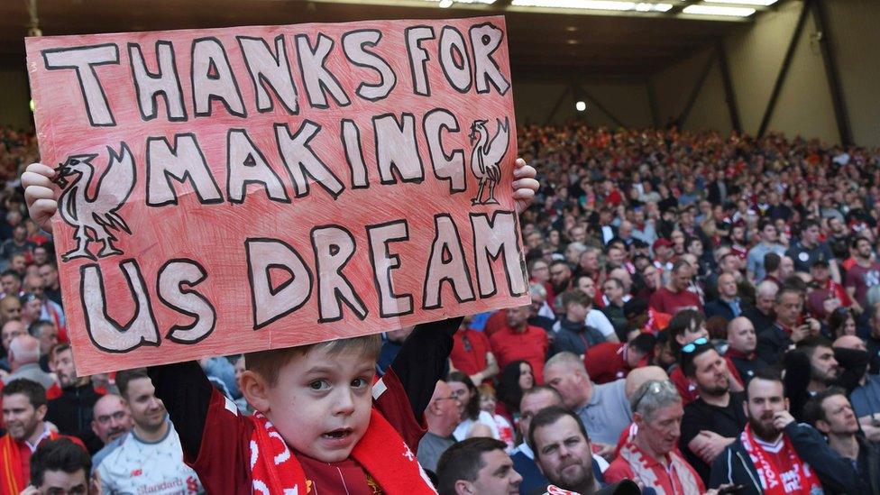 young-fan-holds-up-liverpool-sign.