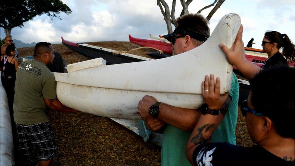 Men lifting canoe