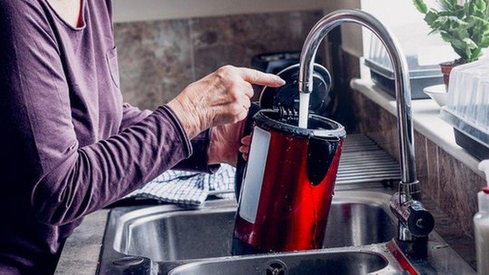 woman fills kettle