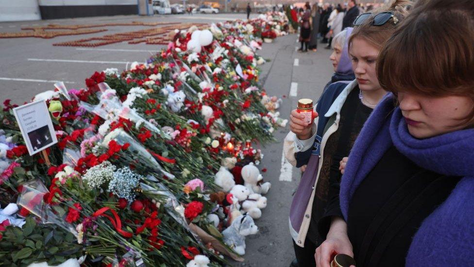 People light candles, to respect the victims of the Crocus City Hall terrorist attack, near the Crocus City Expo Complex, on March 25, 2024