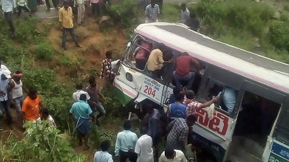 Onlookers and rescuers gather around the bus in Telangana state.