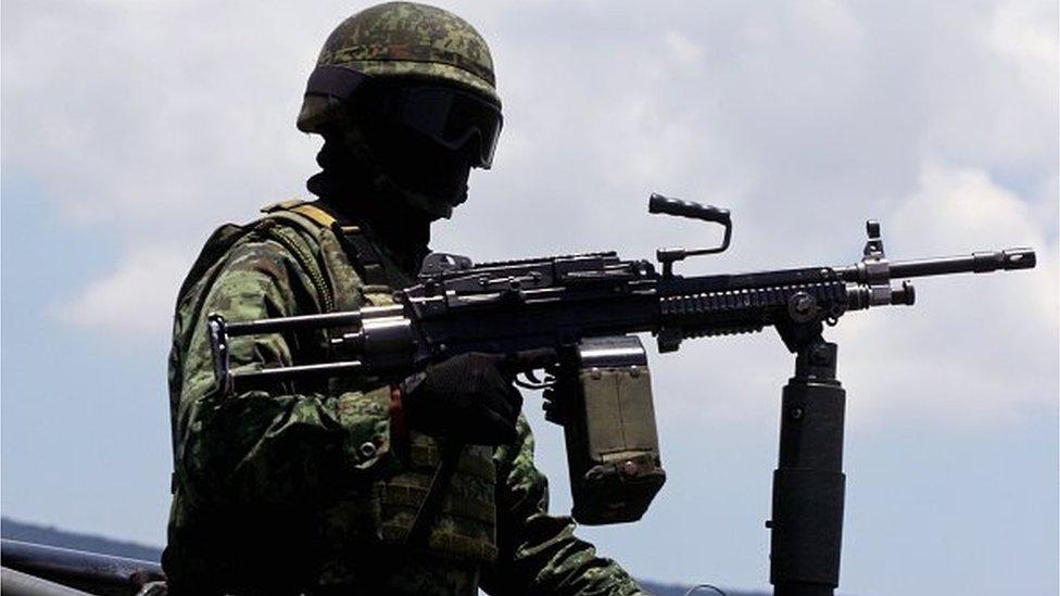 Mexican soldiers patrol the ranch along the Jalisco-Michoacan highway in Tanhuato, Michoacan State, on May 23, 2015