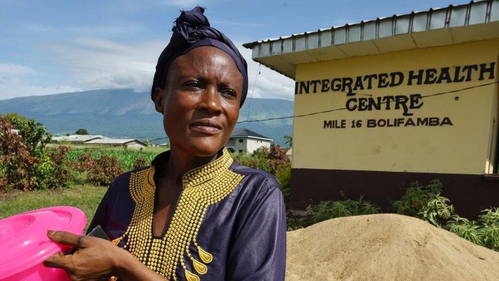 A woman displaced from her home in Cameroon outside a health centre in Buea