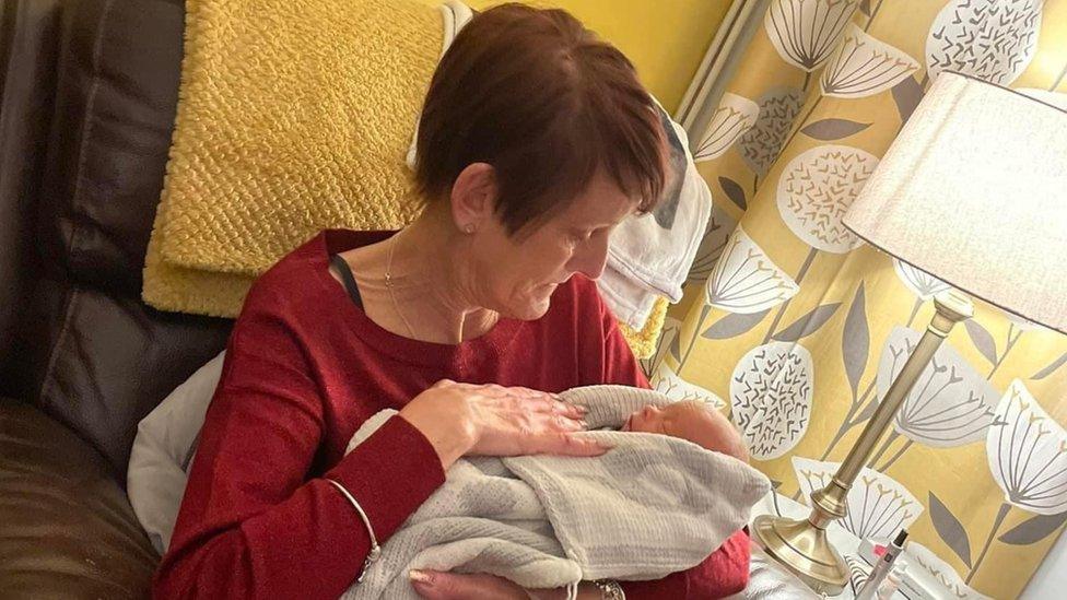 Julie Stocks holds her grandson after he was born