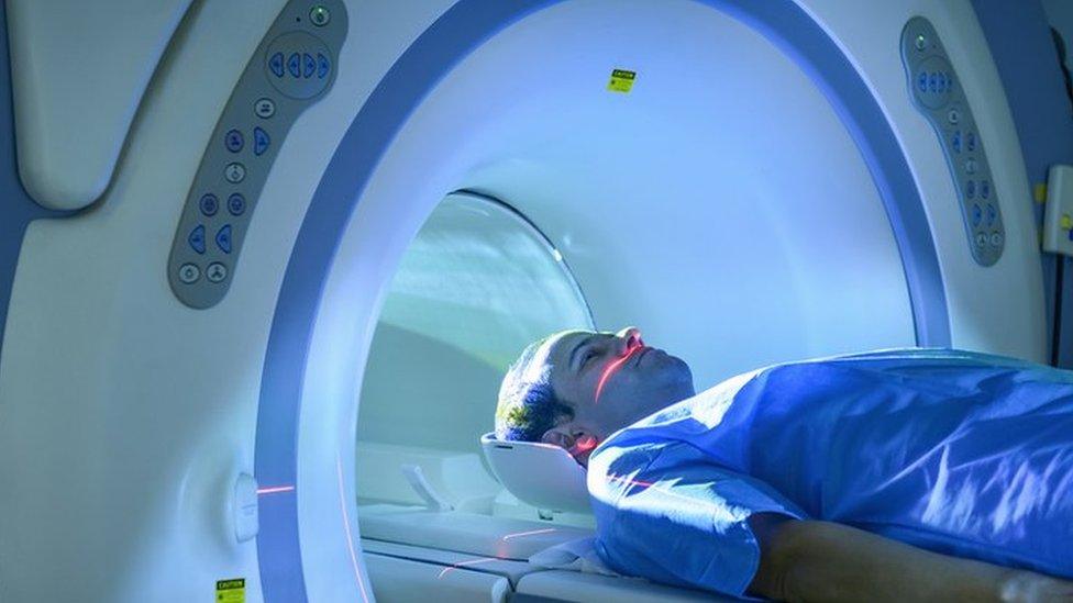 A stock image of a man going through an MRI scanner