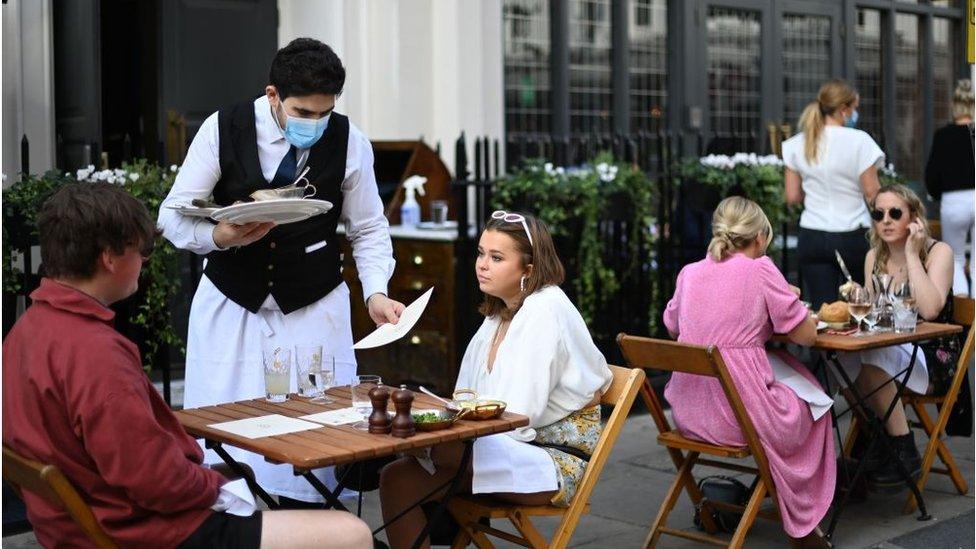 A waiter in a mask