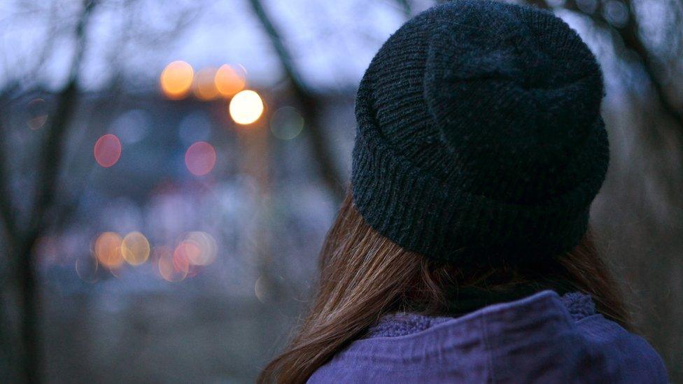 Anonymous girl looking at city lights