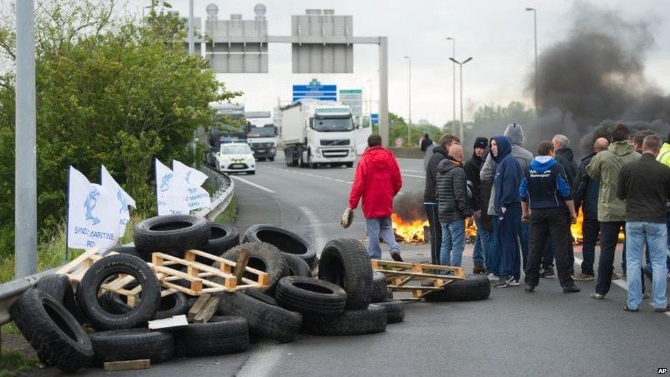 Striking ferry workers burn tyres as they block a ramp leading into the Eurotunnel