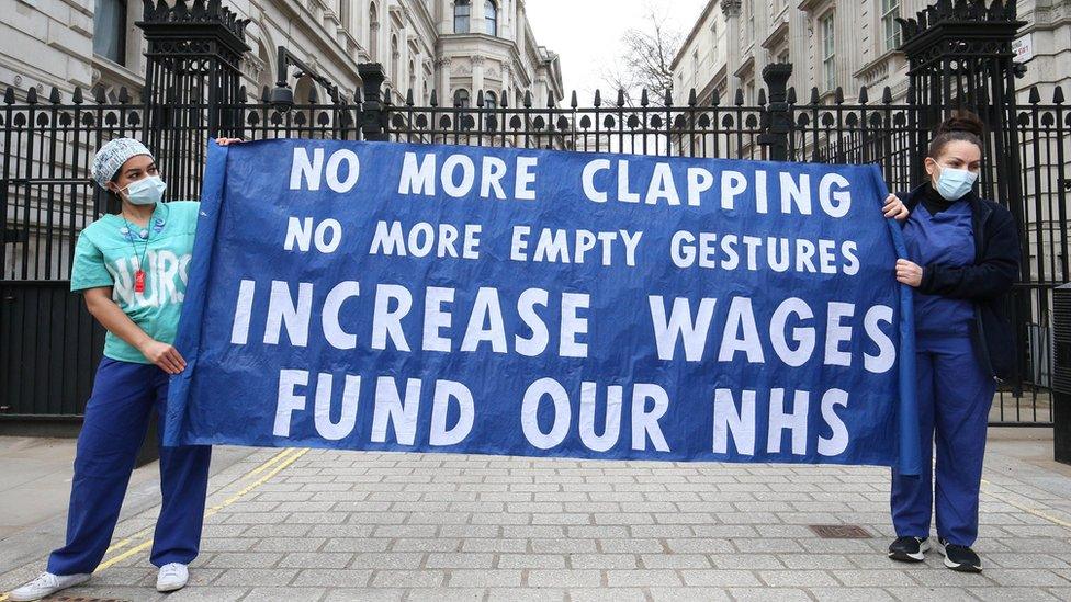 Protesters hold sign outside Downing Street gates