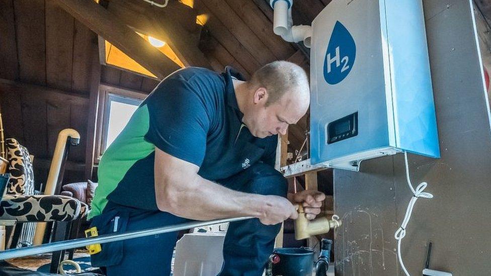 A man fitting a hydrogen boiler