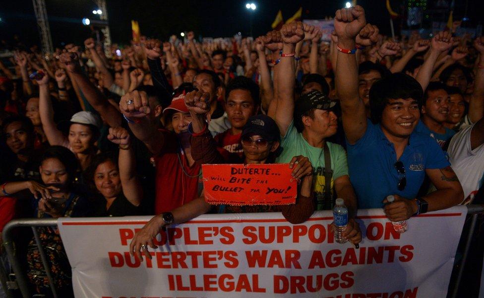 Supporters of President Rodrigo Duterte raise clenched fists during a rally at a park in Manila on February 25, 2017