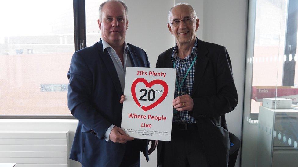 Andrew RT Davies and a campaigner holding a sign saying "20's Plenty Where People Live"