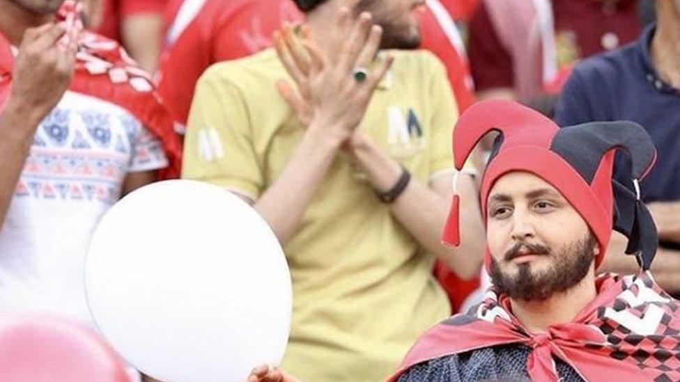 Woman disguised as a man viewing the game