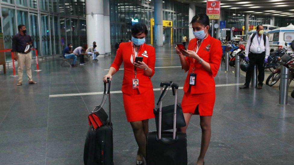 AirAsia Airlines Air hostess wearing protective mask watch on his smartphone at the Netaji Subhas Chandra Bose International Airport on June 04, 2020 in Kolkata, India.