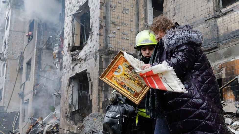 People outside a missile-struck building in Kyiv