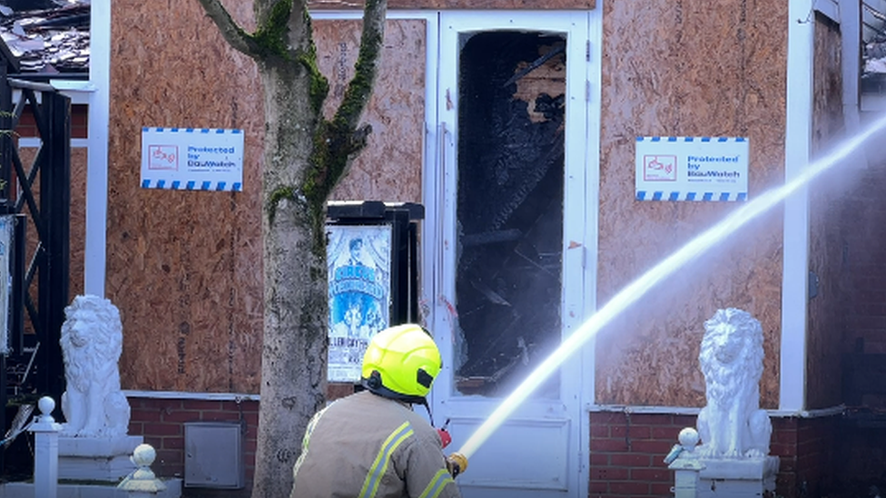 Firefighter spraying water at a building