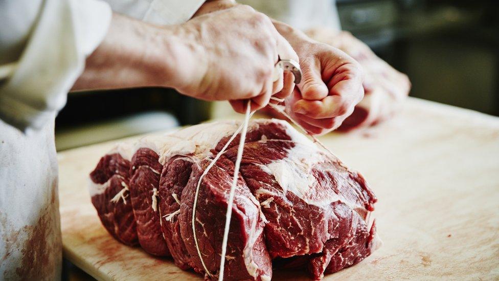 Butcher handling meat