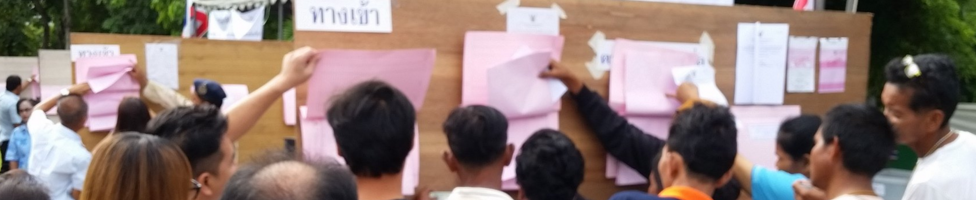 Thai voters check their names on registration lists at a polling station in Bangkok