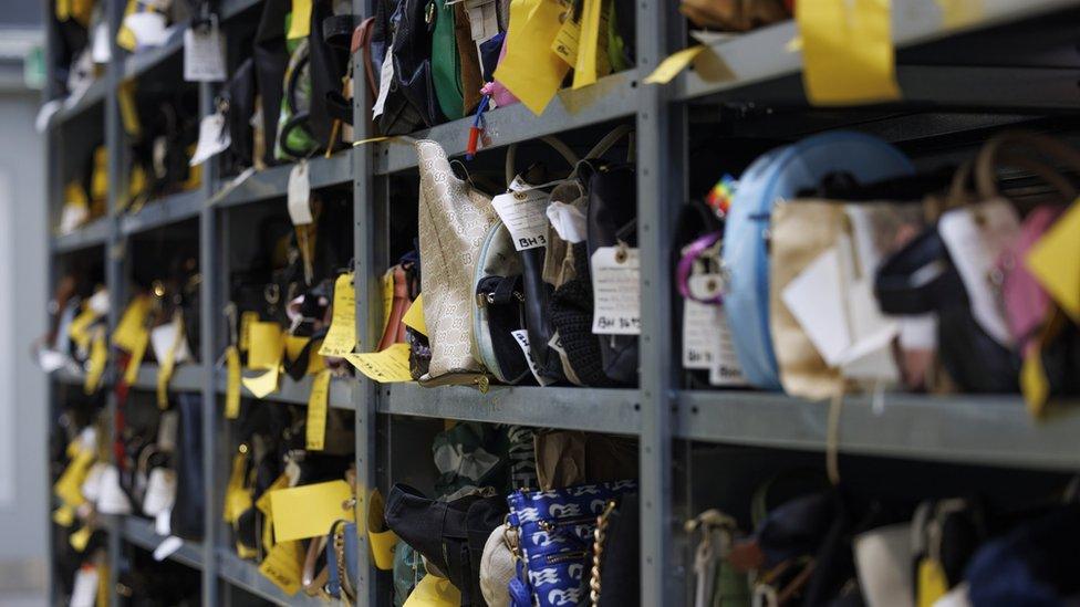 Image of pigeonholes containing small bags and other items labelled with white and yellow tags