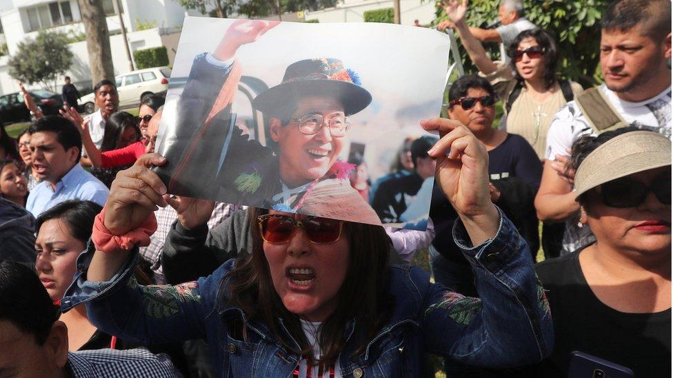 A supporter holds a picture of former President Alberto Fujimori as they wait outside his residence, after a judge annulled a presidential pardon and ordered his immediate capture and return to prison, in Lima, Peru October 3, 2018