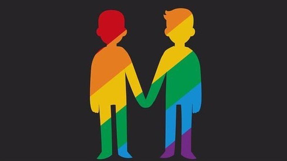 Silhouettes of 2 men holding hands in rainbow colours