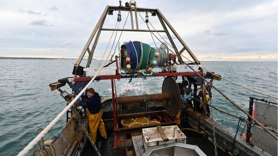 Newhaven fishing boat skipper Neil Whitney prepares his boat for the first trawl of the day, off the south-east coast of England