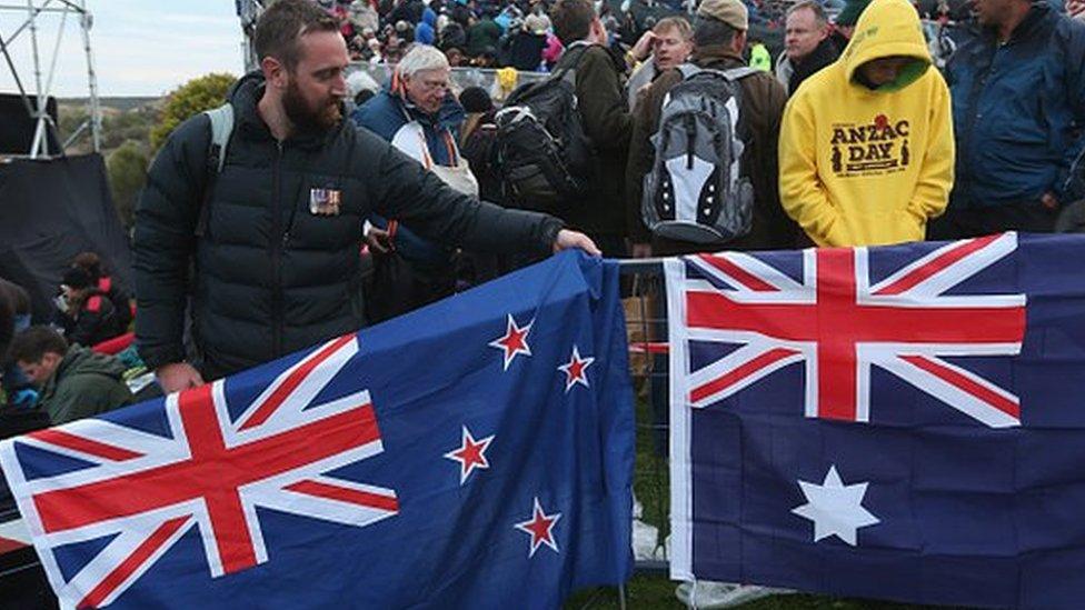 Visitors pack up New Zealand (L) and Australian flags at the conclusion of the Dawn Service at the Anzac Commemorative Site, which is the main event to commemorate Australian soldiers who died during the Gallipoli campaign, on the campaign's centenary on 25 April 2015 near Eceabat, Turkey.