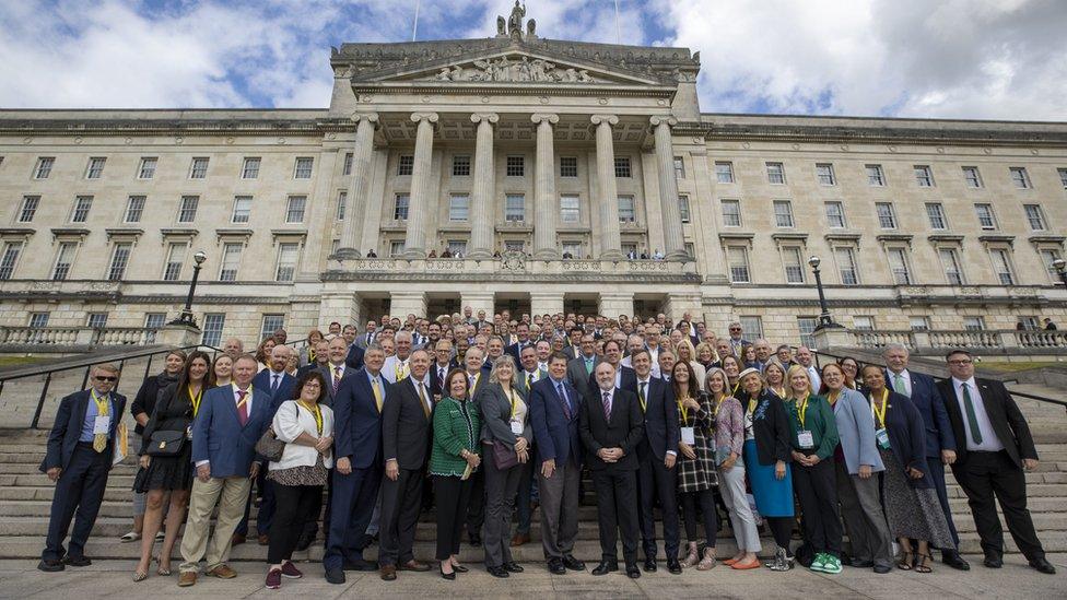 US politicians form a large group as they pose for a photo on the steps of Parliament Buildings, Stormont