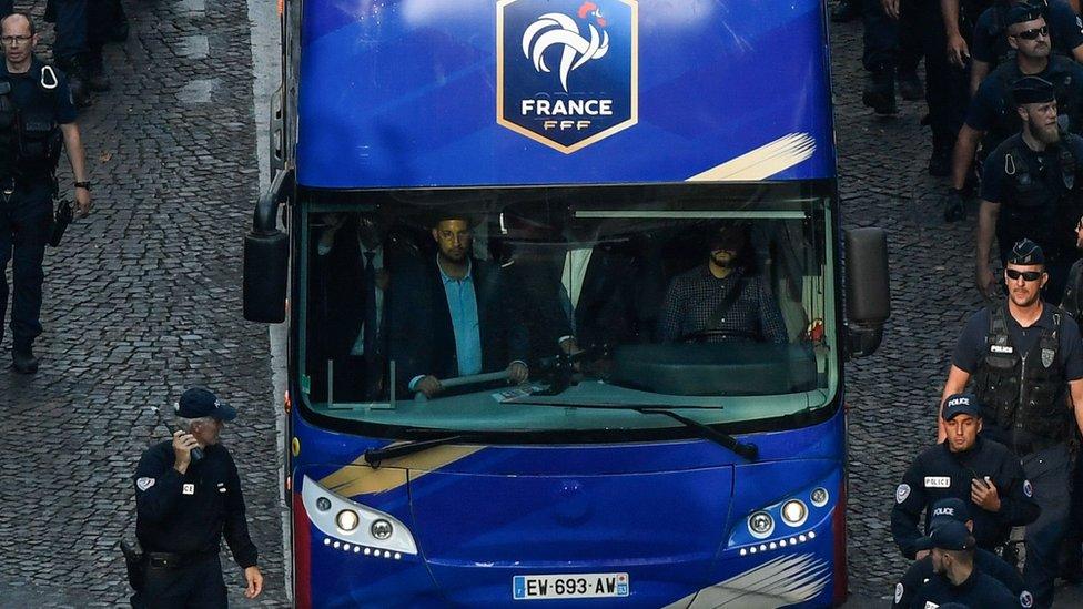 Elysée Chief Security Officer Alexandre Benalla is seen in the driver cabin (front L) of the bus carrying France's team players as they arrive on the Champs-Elysees avenue in Paris, on July 16, 2018