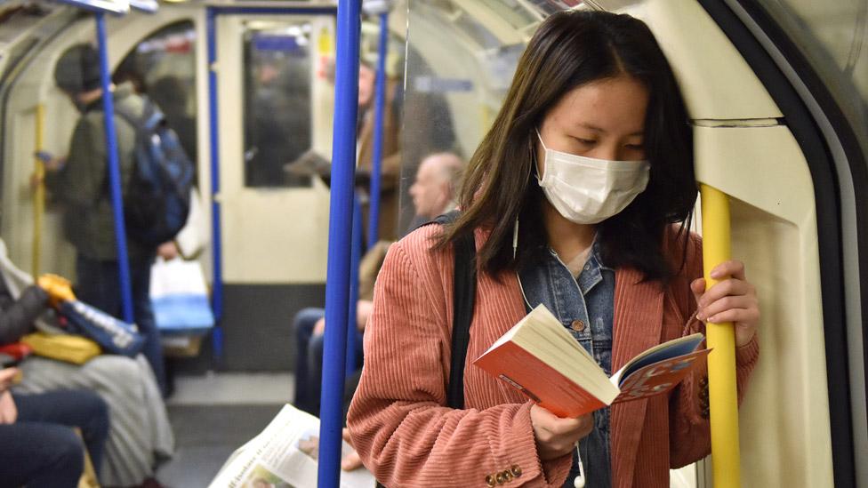 Woman reading a book on the London Underground`