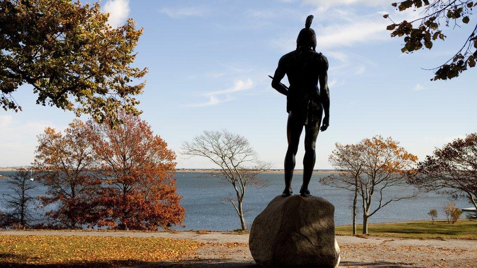 A Wampanoags statue stands on a hill overlooking Plymouth Harbor in Massachusetts.