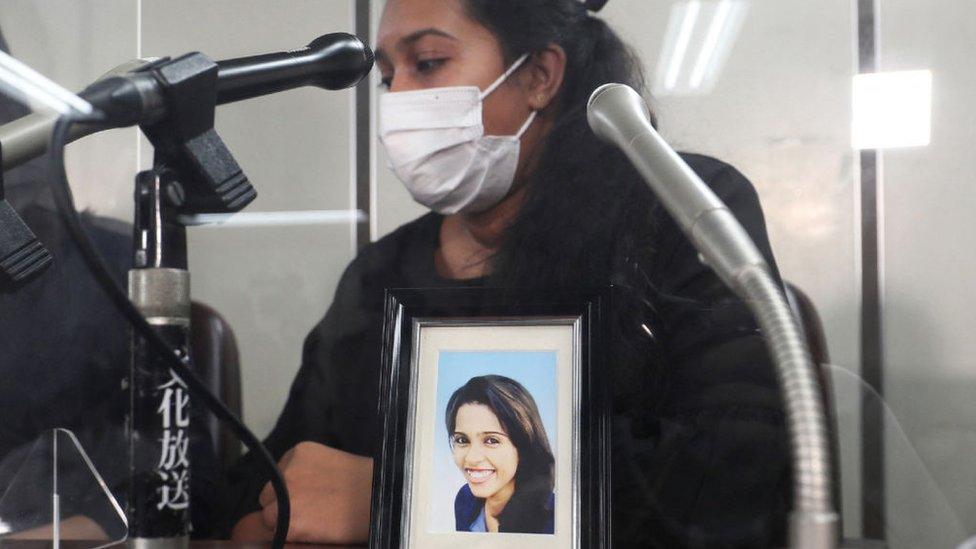 This picture taken on August 12, 2021 shows Sri Lankan woman Poornima, the younger sister of Wishma Sandamali who died at the Nagoya Regional Immigration Bureau's facility in March of this year, attending a press conference with a portrait of her late sister, in Tokyo.