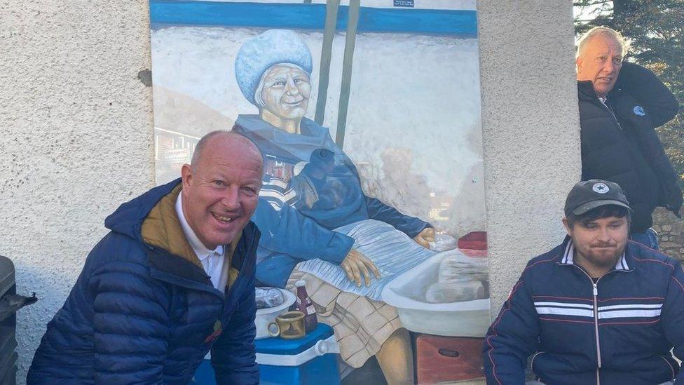 Two men in front of Lillian's mural