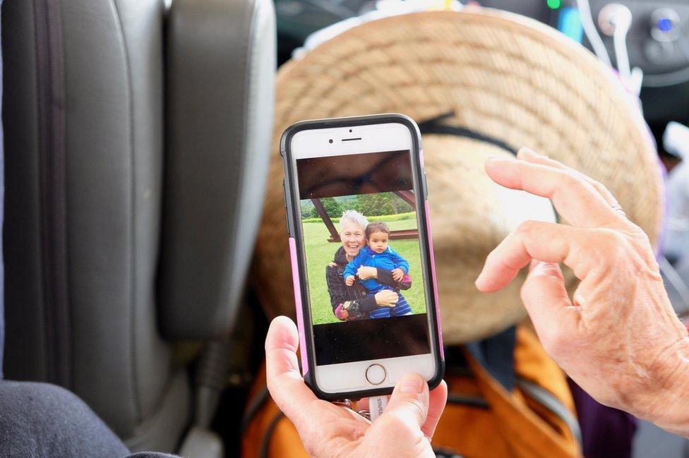 A grannies shows a picture of her family