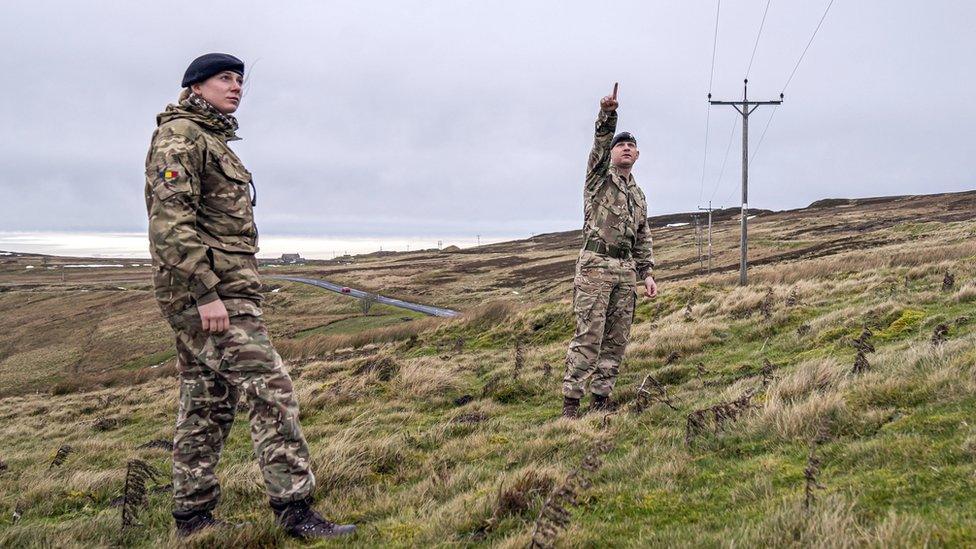 Soldiers point to energy poles in remote part of the dale