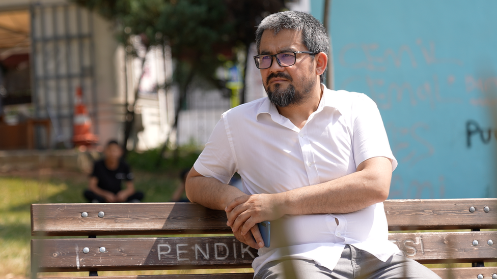 Abdurehim Paraç, pictured sitting on a bench in sunlight in Istanbul