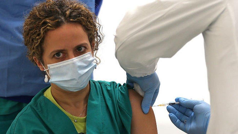 A nurse inoculates a fellow health worker in Naples, Italy. 27 Dec 2020