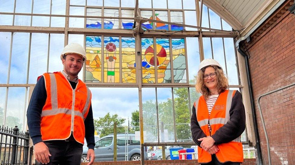 Stained glass artist Cate Watkinson and Nexus Project Manager Simon Manley next to the canopy and stained glass art work at Monkseaton Metro station